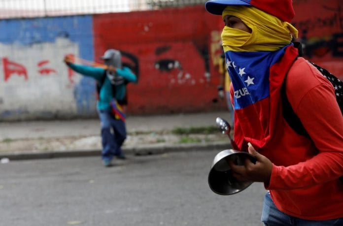 A demonstrator holds a pot as he attends the'march of the empty pots' against Venezuelan President Nicolas Maduro's government in Caracas